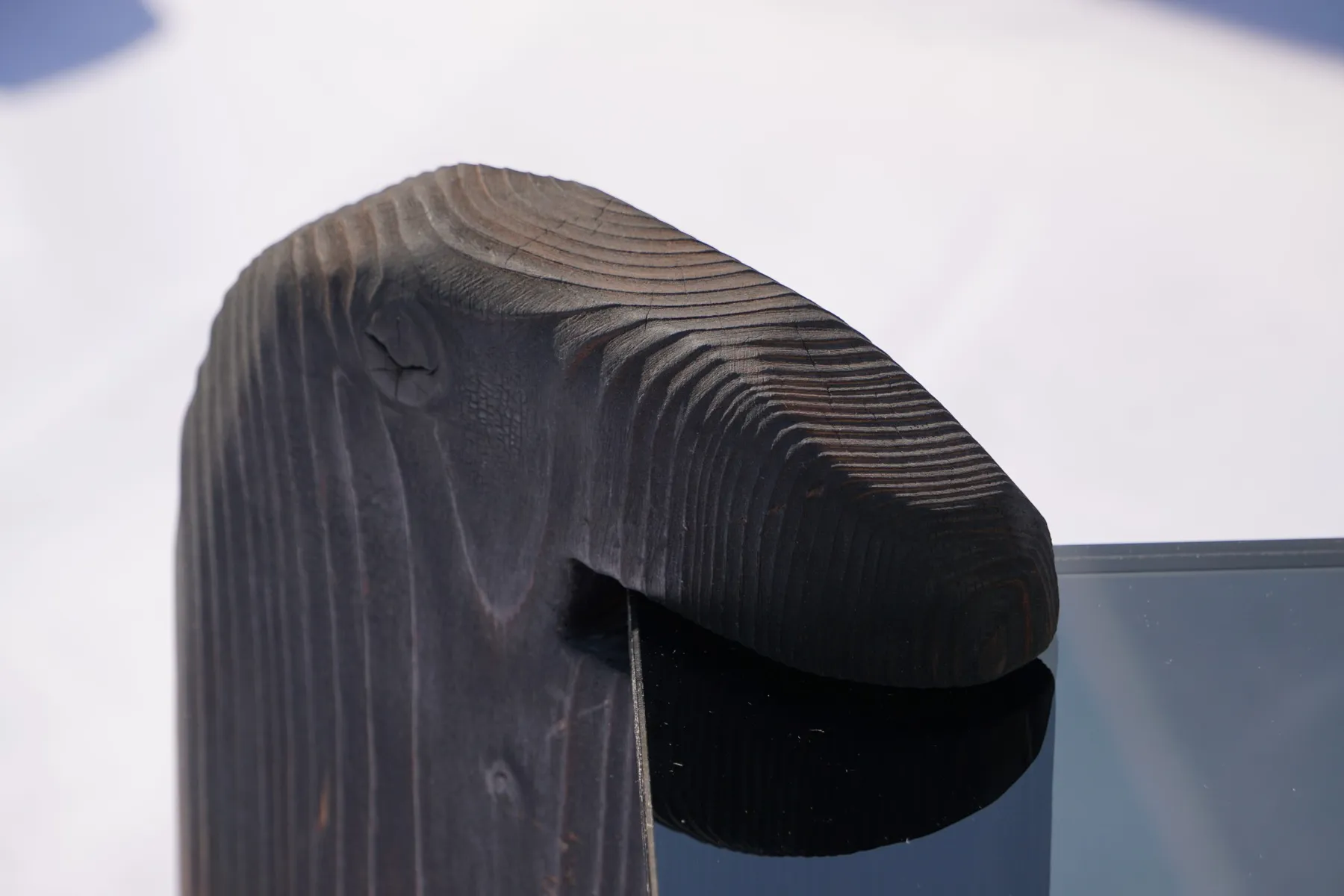 Nahaufnahme des geflammten Holzkopfs über der Glasplatte