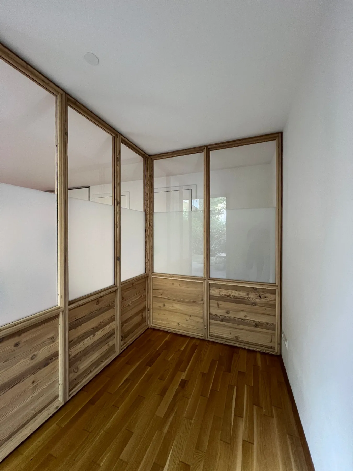 Blick in die abgetrennte Kabine mit Glasfeldern und Holzbrüstung